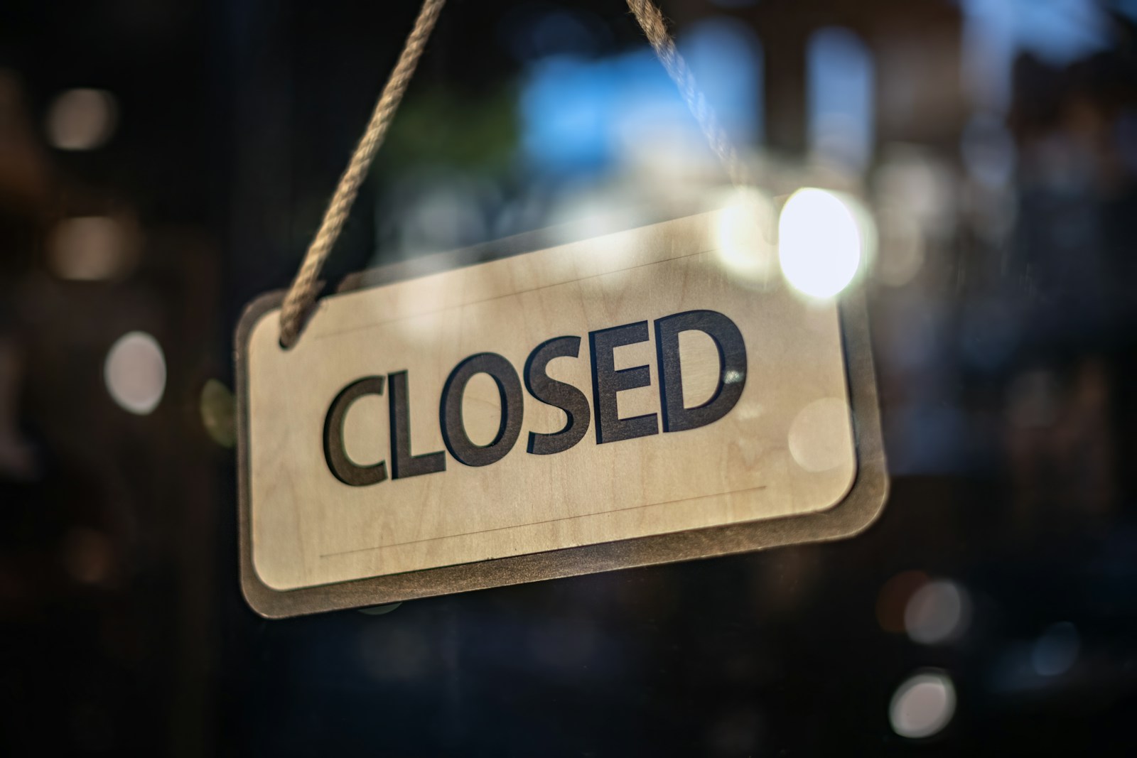 A closed sign hanging from a glass door